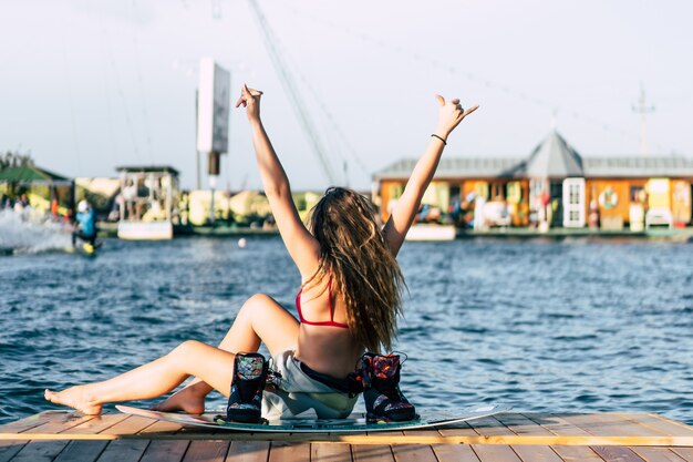 Hermosa chica con el pelo largo con un wakeboard