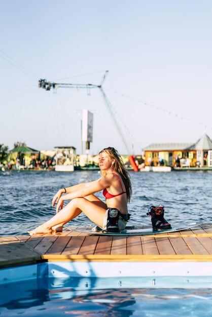 Hermosa chica con el pelo largo con un wakeboard