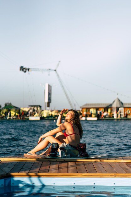 Hermosa chica con el pelo largo con un wakeboard