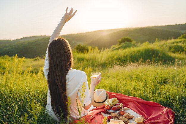 Hermosa chica en un picnic en el campo asummer