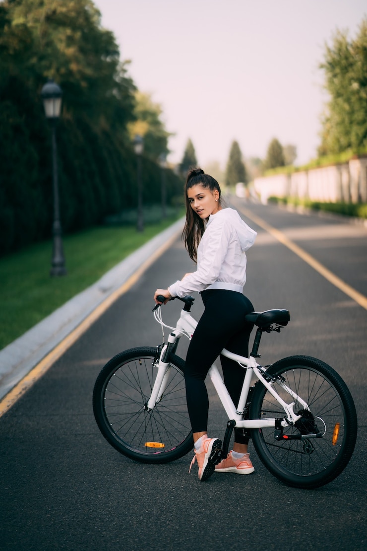 Foto gratuito hermosa chica posando en bicicleta blanca. camina en la naturaleza.