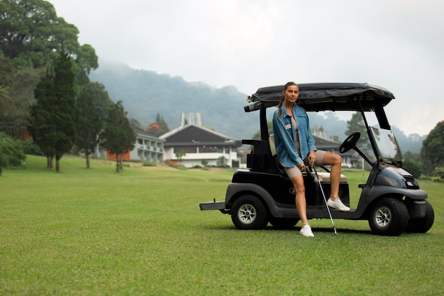 Foto gratuita hermosa chica posando en el campo de golf