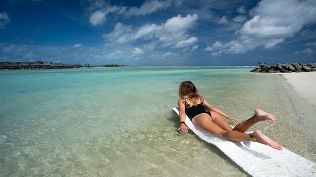 Hermosa chica posando contra el telón de fondo del océano azul Maldivas