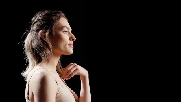 Foto gratuita hermosa chica que se siente feliz y natural con la piel desnuda, posando en el estudio sin maquillaje. mujer segura de sí misma riéndose y creando una campaña publicitaria para el cuidado de la piel, promoviendo la positividad corporal de autoaceptación.