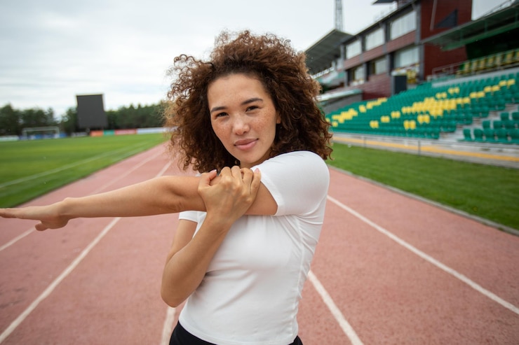 Foto gratuito la hermosa chica rizada se calienta en el campo de deportes