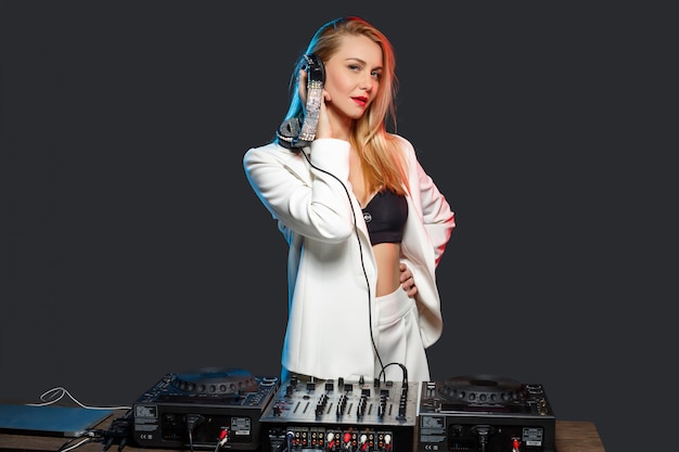 Hermosa chica rubia DJ en cubiertas