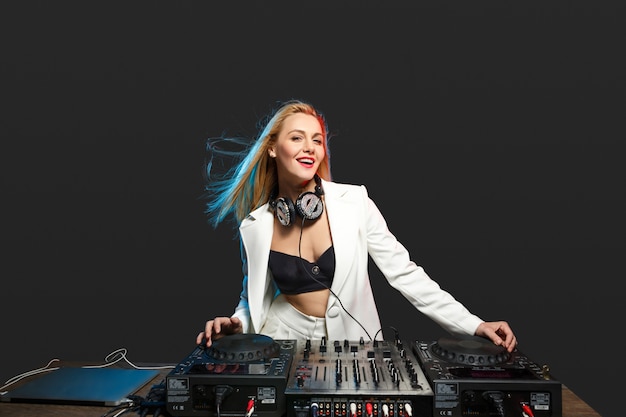 Hermosa chica rubia DJ en cubiertas