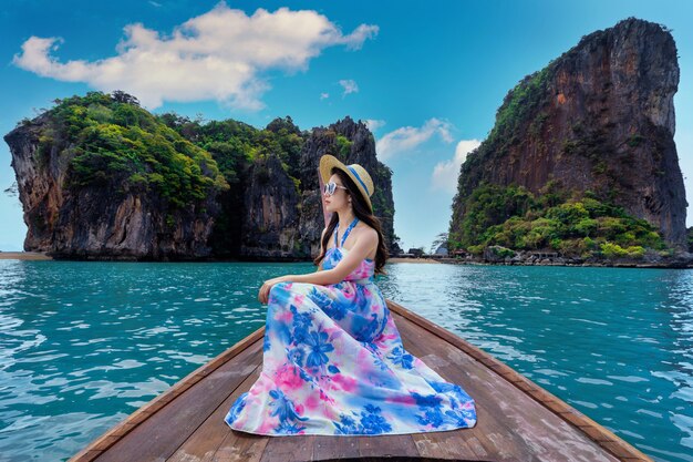 Hermosa chica sentada en el barco en la isla de James Bond en Phang nga, Tailandia.