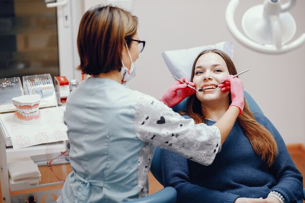 Hermosa chica sentada en la oficina del dentista