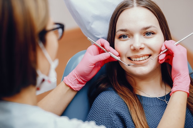 Hermosa chica sentada en la oficina del dentista