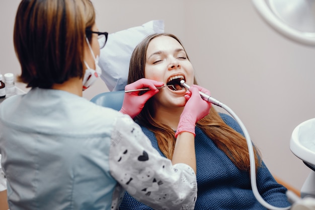 Hermosa chica sentada en la oficina del dentista