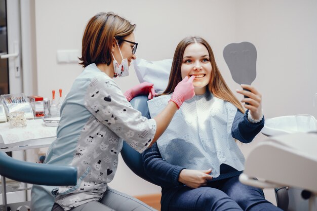 Hermosa chica sentada en la oficina del dentista