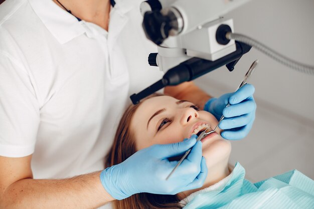 Hermosa chica sentada en la oficina del dentista