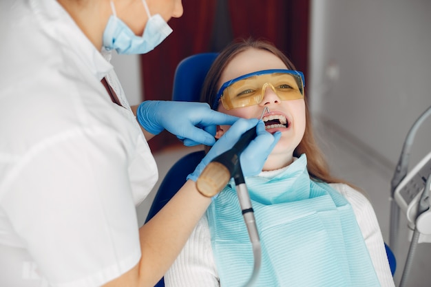 Hermosa chica sentada en la oficina del dentista