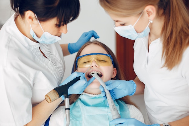 Hermosa chica sentada en la oficina del dentista