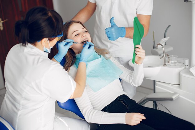 Hermosa chica sentada en la oficina del dentista