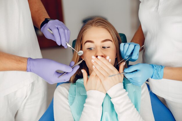 Hermosa chica sentada en la oficina del dentista