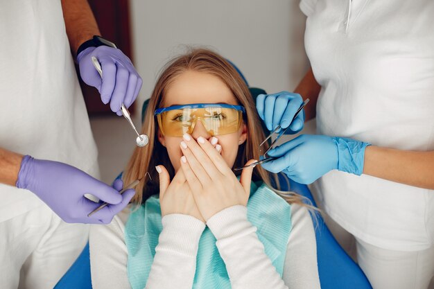 Hermosa chica sentada en la oficina del dentista