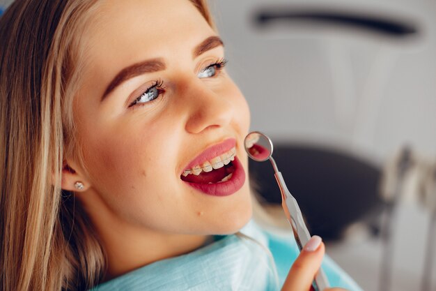 Hermosa chica sentada en la oficina del dentista