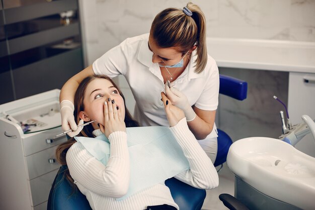 Hermosa chica sentada en la oficina del dentista