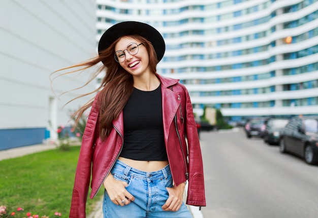 Hermosa chica con sincera sonrisa posando en la calle