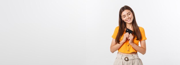 Hermosa chica sonriente y confiada que muestra una tarjeta negra en la mano aislada sobre el fondo blanco