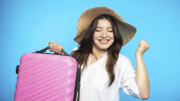 Hermosa chica sonriente con sombrero se va de vacaciones y quiere descansar