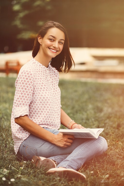 Hermosa chica sosteniendo un libro abierto