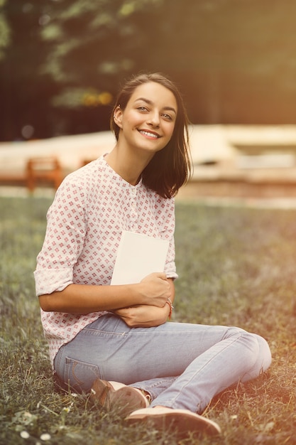 Hermosa chica sosteniendo un libro abierto