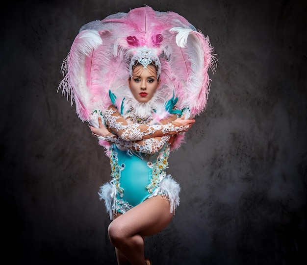 Foto gratuita hermosa chica en un suntuoso traje de plumas de carnaval. aislado en un fondo oscuro.