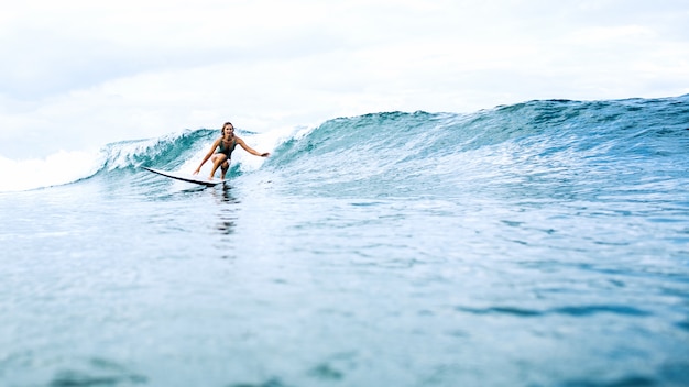 hermosa chica surfista montando en un tablero