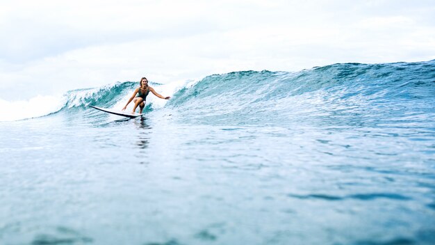 hermosa chica surfista montando en un tablero