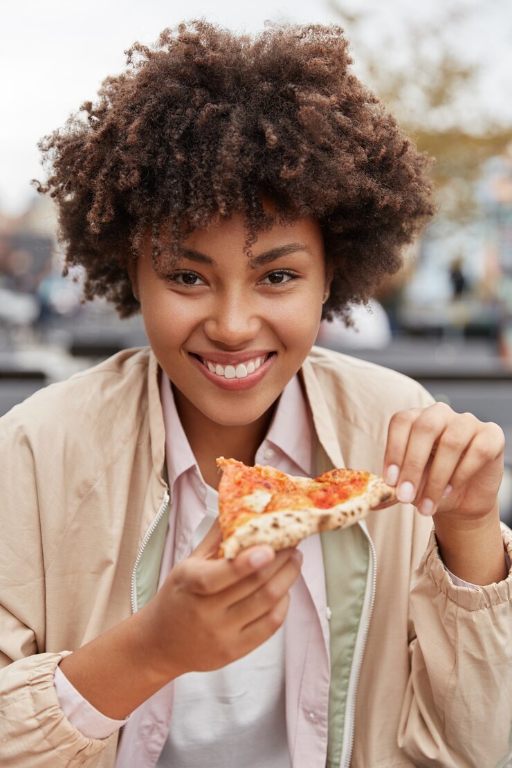 Foto gratuito hermosa chica tiene deliciosa pizza después de un duro día de trabajo