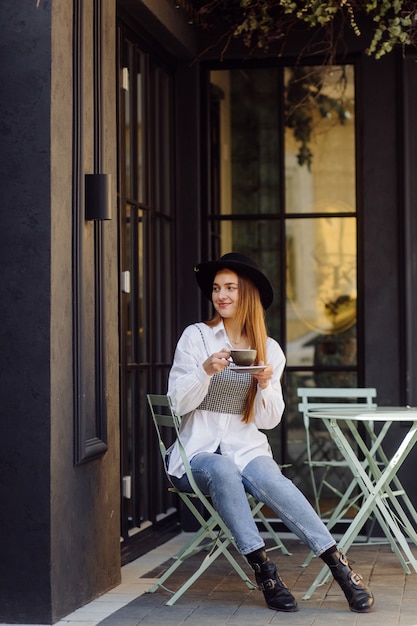 Hermosa chica tomando café en el café