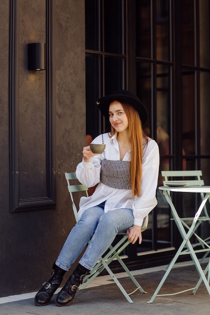 Hermosa chica tomando café en el café