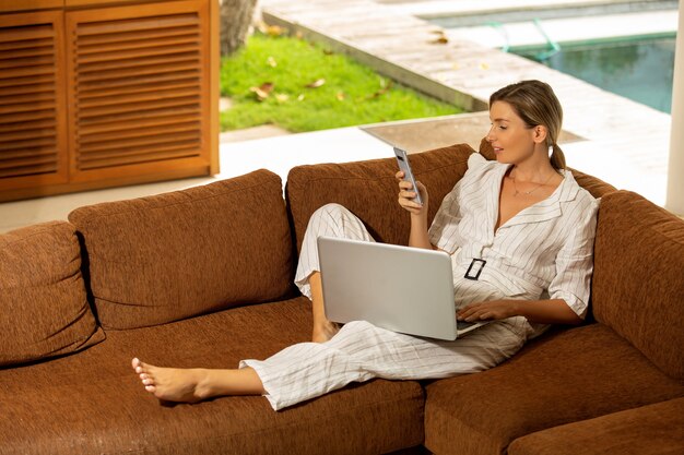 Hermosa chica trabaja en casa en la computadora.