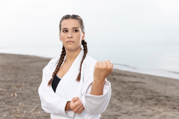 Hermosa chica en traje de karate al aire libre