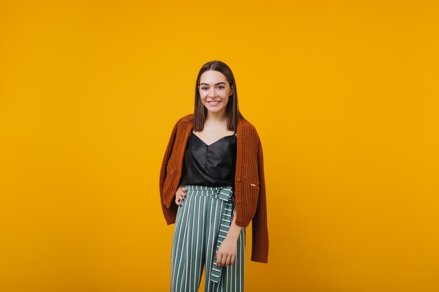 Hermosa chica en traje de moda sonriendo. riendo mujer encantadora con cabello oscuro.