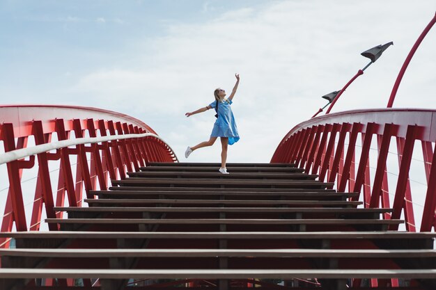 hermosa chica en un vestido azul posando en el puente