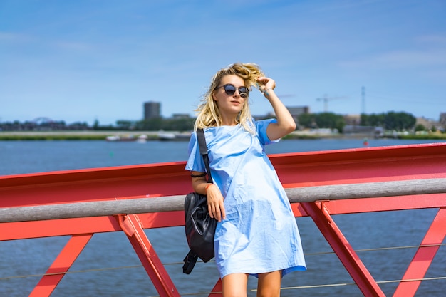 hermosa chica en un vestido azul posando en el puente