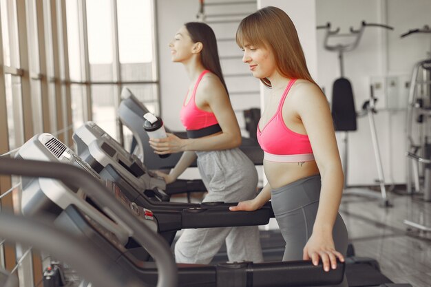 Una hermosa chicas en un gimnasio en una pista de carreras