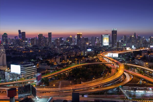 Hermosa ciudad con luces cerca de su carretera más transitada en la noche.