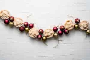 Foto gratuita hermosa composición de bolas de árbol de navidad y pasteles de carne picada sobre una superficie blanca