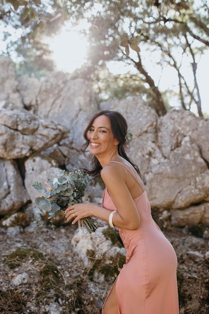 Hermosa dama de honor sosteniendo un ramo de flores