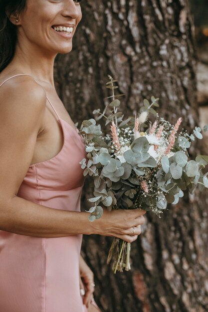 Hermosa dama de honor sosteniendo un ramo de flores