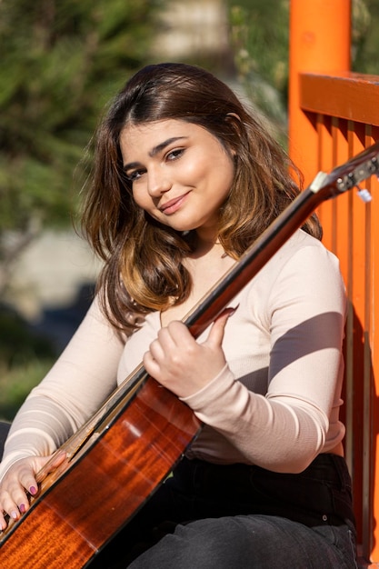 Hermosa dama sonriente tocando la guitarra Foto de alta calidad