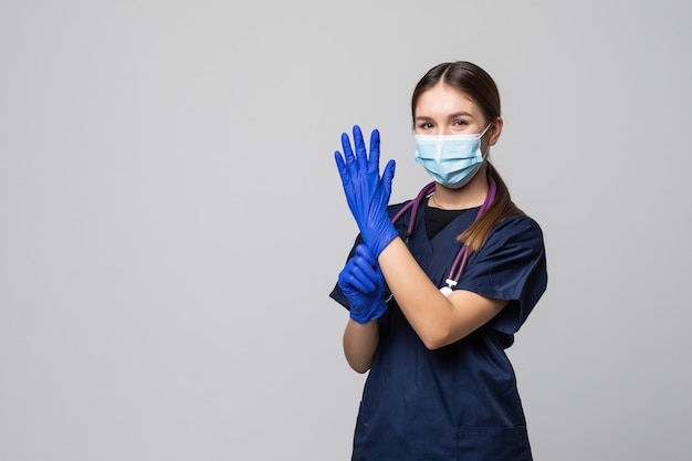 Hermosa doctora o enfermera con máscara protectora y guantes de látex o goma con espacio de copia