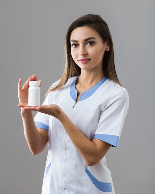 Hermosa doctora sosteniendo pastillas