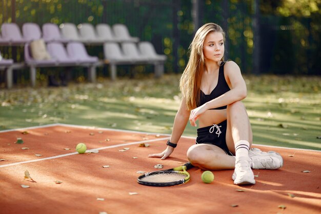 Hermosa y elegante chica en la cancha de tenis