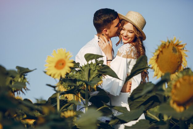 Hermosa y elegante pareja en un campo con girasoles